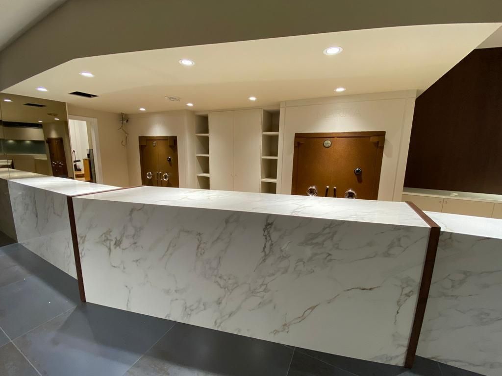 Un lungo bancone di marmo bianco in una stanza con una lampada a soffitto.