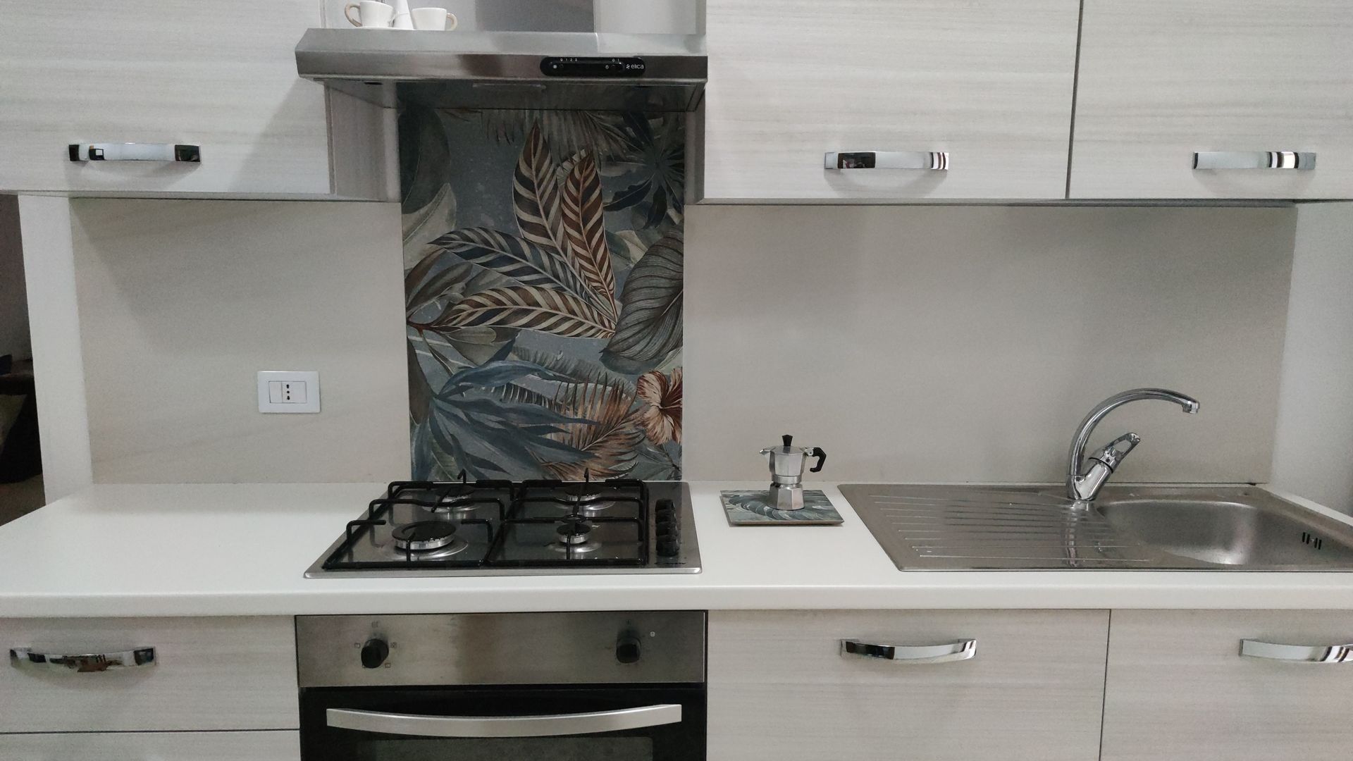 Una cucina con piano cottura, forno, lavello ed elettrodomestici in acciaio inossidabile.