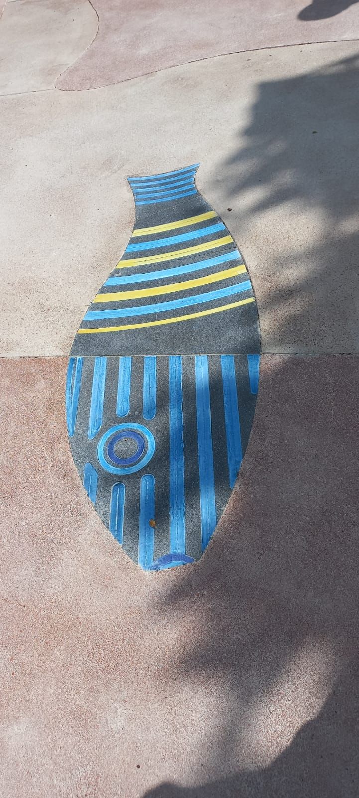 Un disegno di un pesce fatto con il gesso sul terreno.