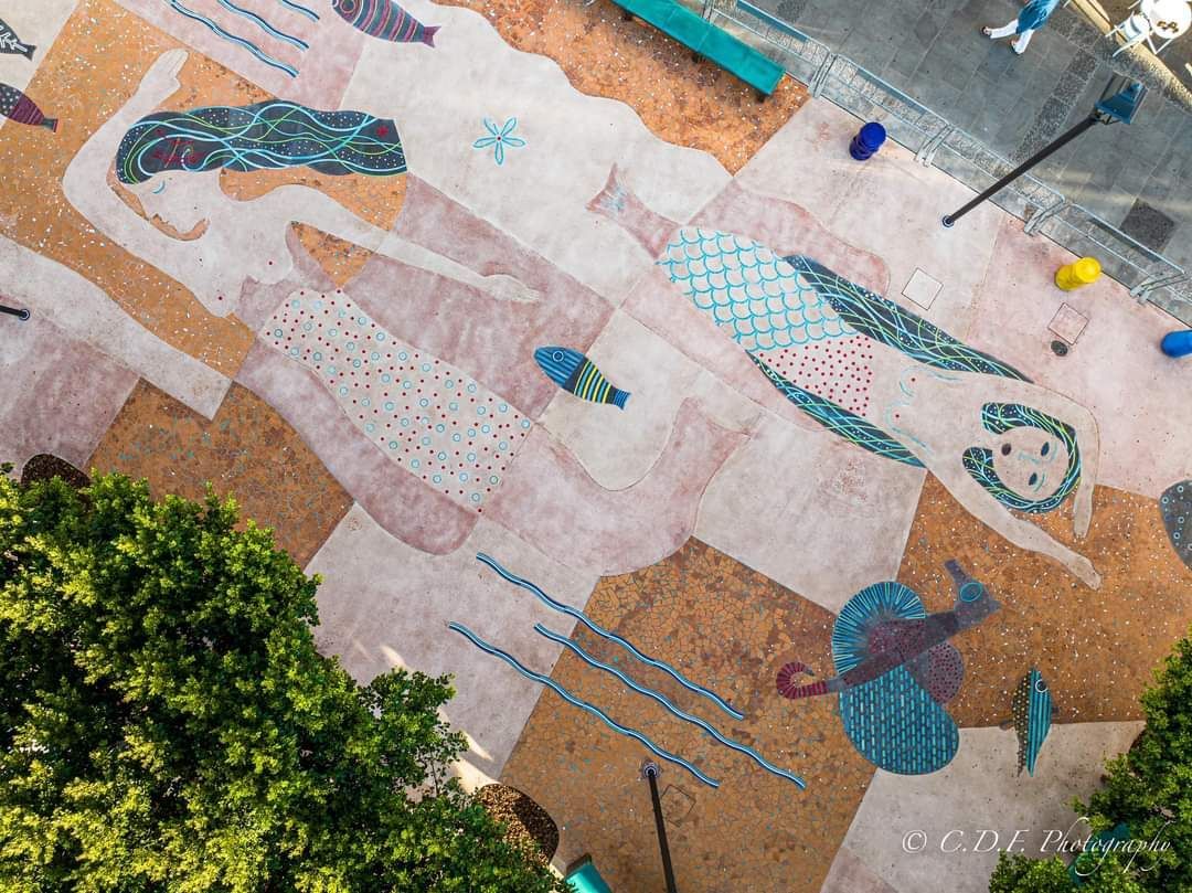 Una veduta aerea di un dipinto di una sirena a terra in un parco.