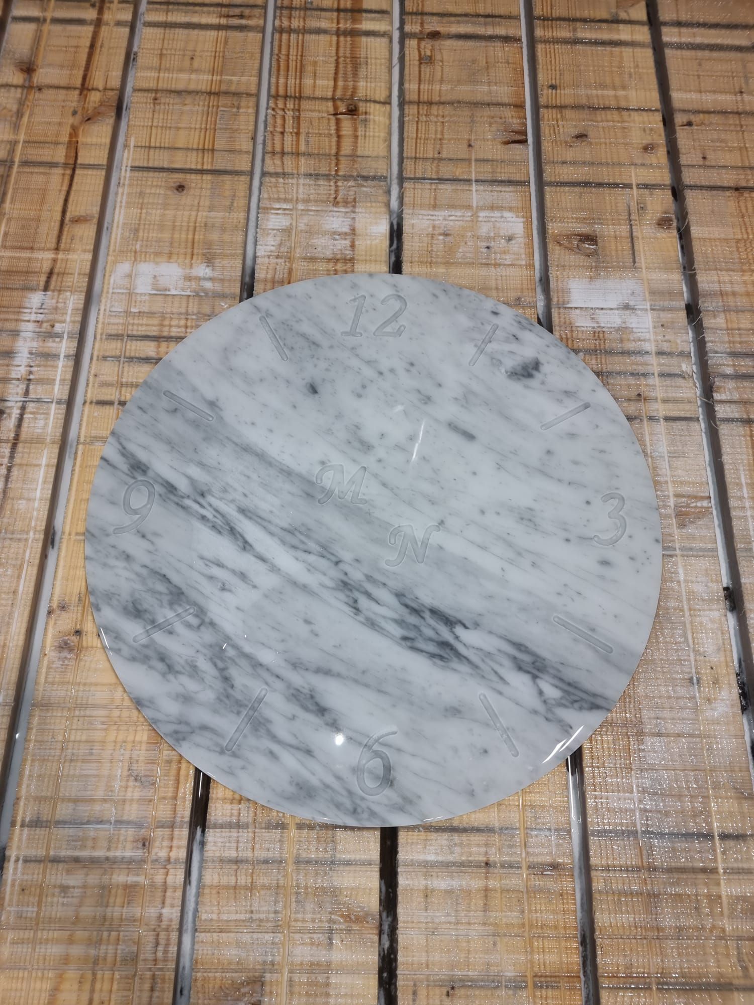 Un tagliere rotondo in marmo è appoggiato su un tavolo di legno.