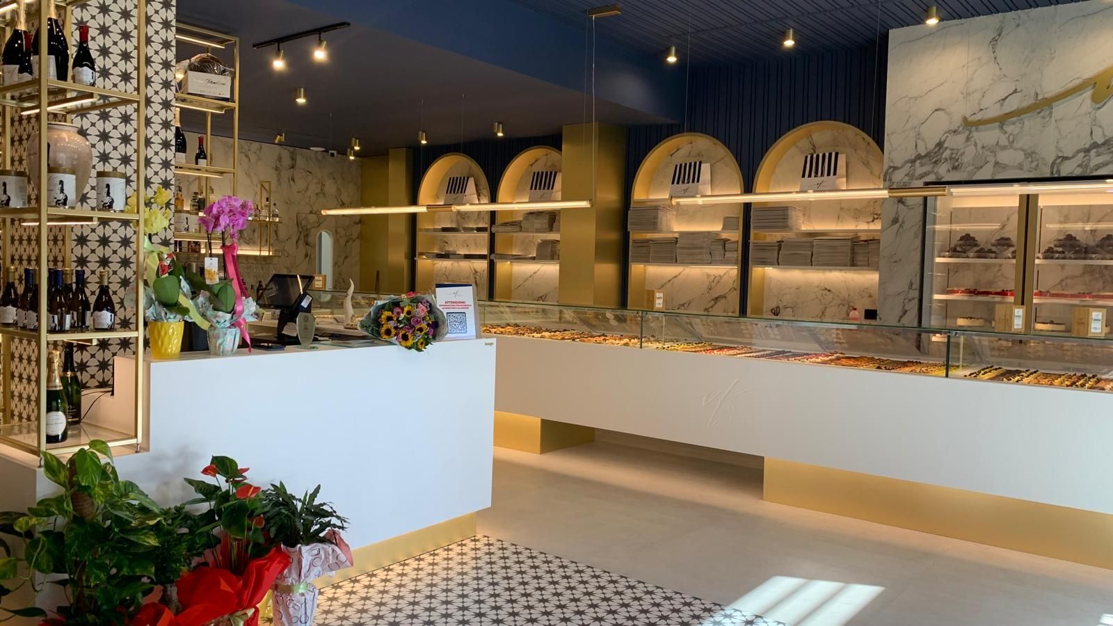 Un panificio con molti scaffali e un bancone.