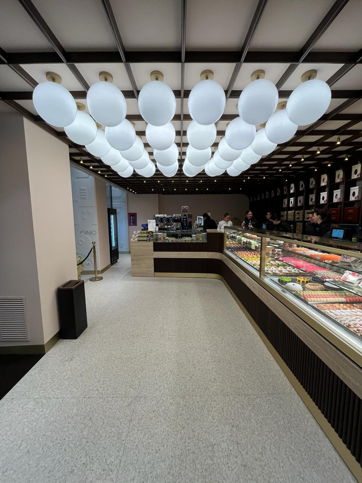 Una panetteria con tante vetrine e palloncini appesi al soffitto