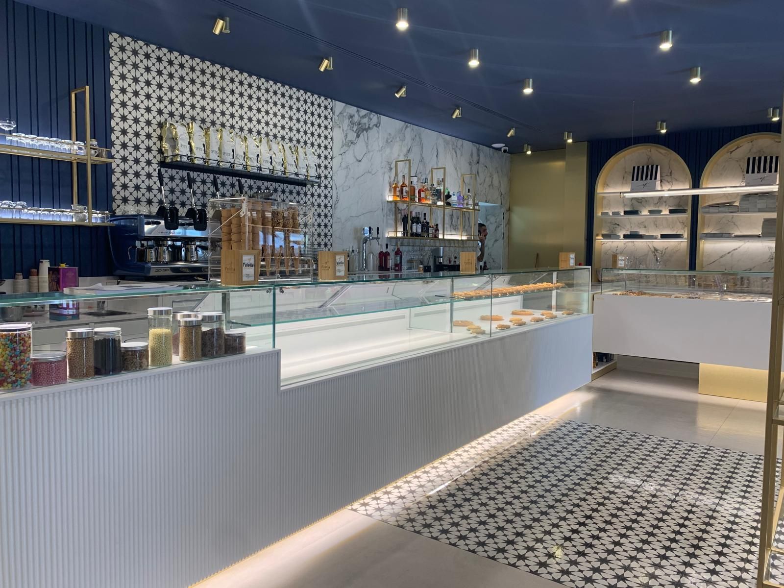 Una panetteria con il soffitto blu e il bancone di vetro.