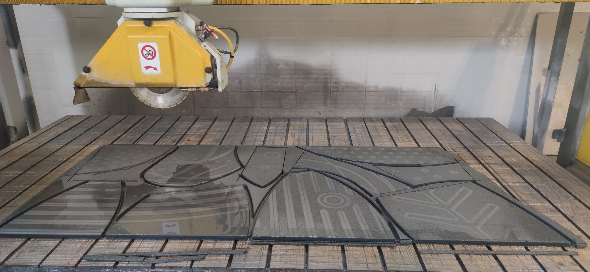 Una macchina sta tagliando un pezzo di vetro su un tavolo.