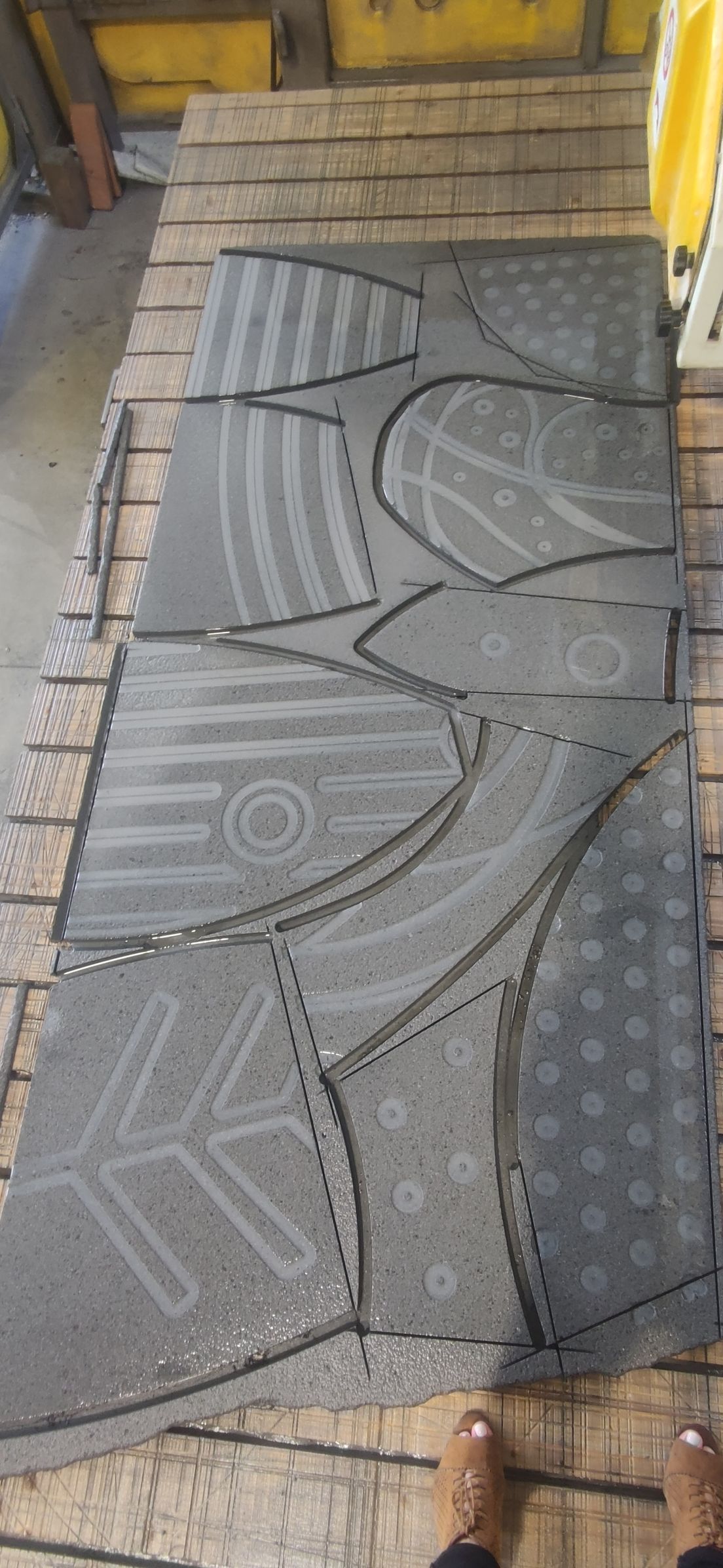 Una persona è in piedi accanto a un pezzo di tappeto su un tavolo di legno.