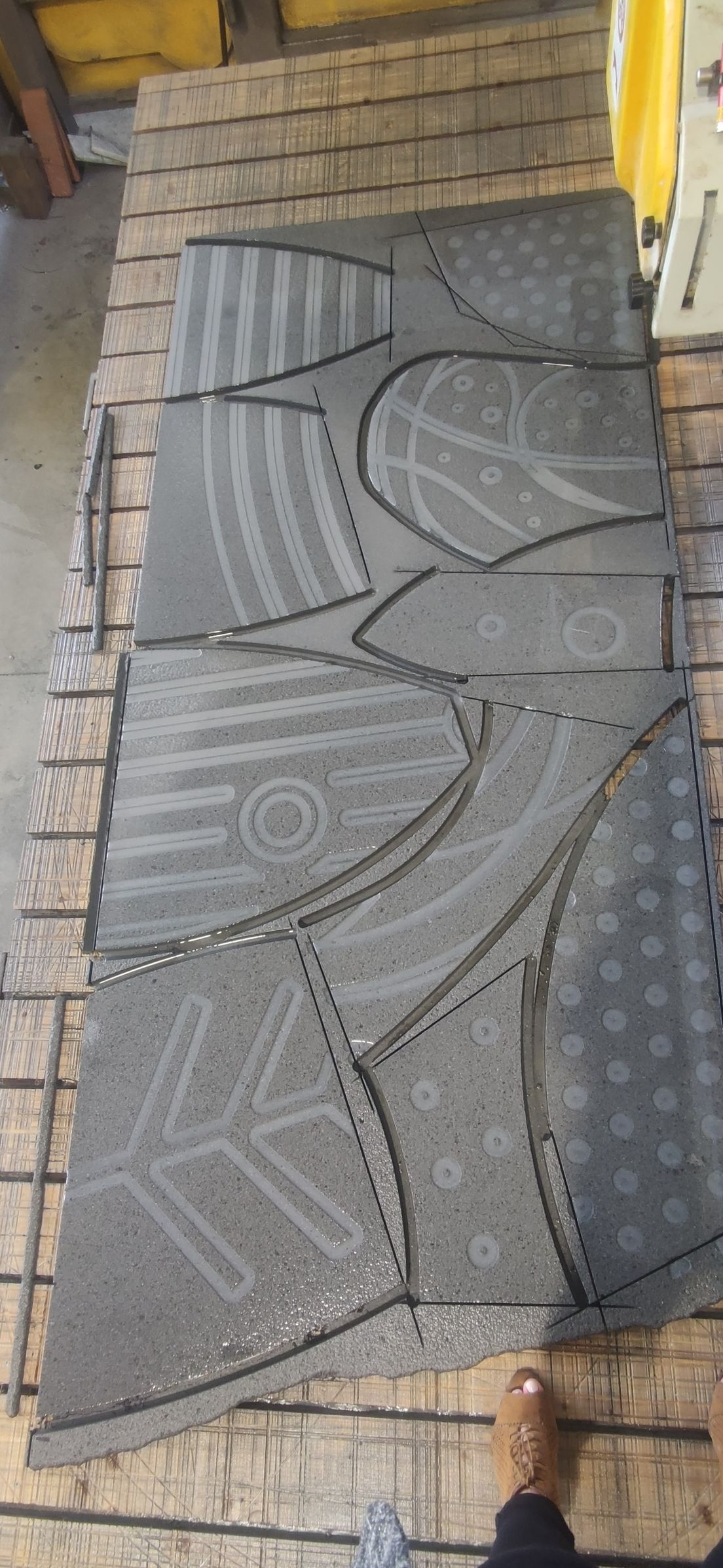 Una persona è in piedi accanto a un pezzo di tappeto su un tavolo di legno.