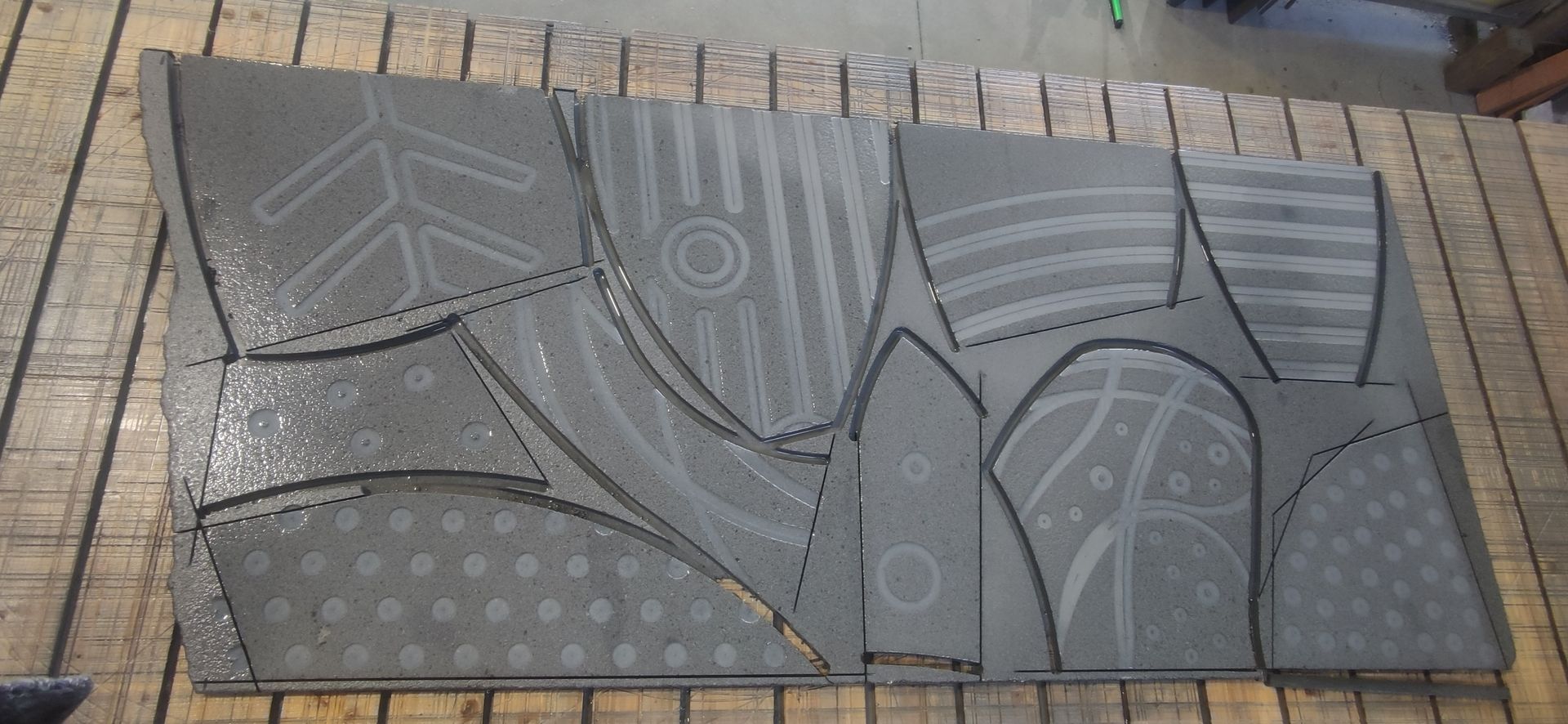 Un pezzo di metallo con un motivo è appoggiato su un tavolo di legno.