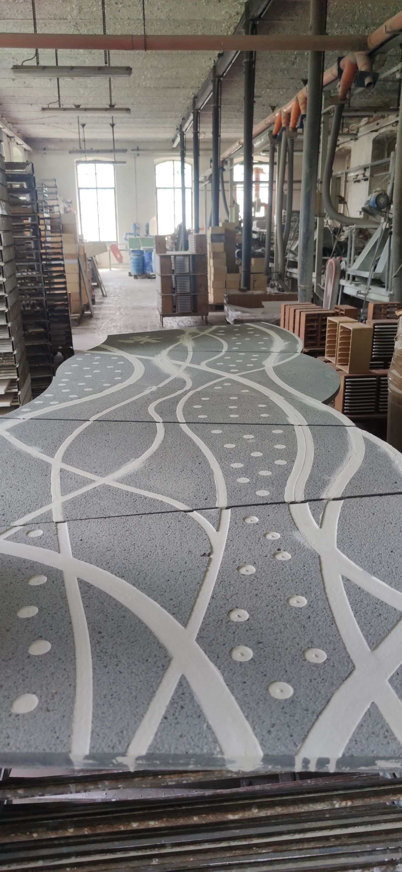 Un grande tappeto è appoggiato su un tavolo in una fabbrica.