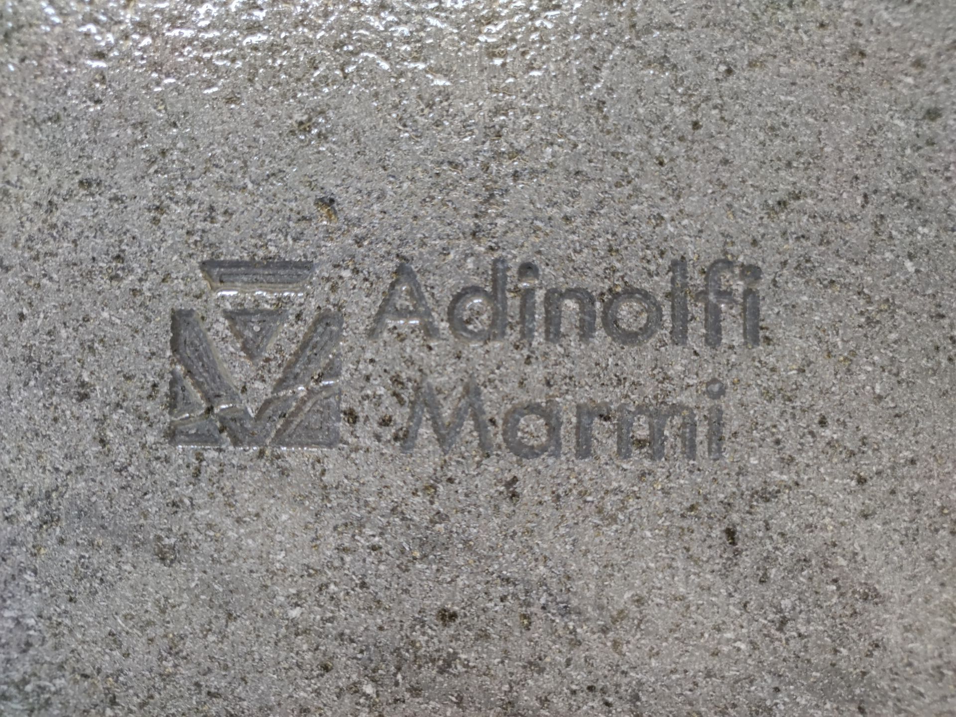 Un primo piano di una superficie grigia con la parola adinolfi scritta sopra.