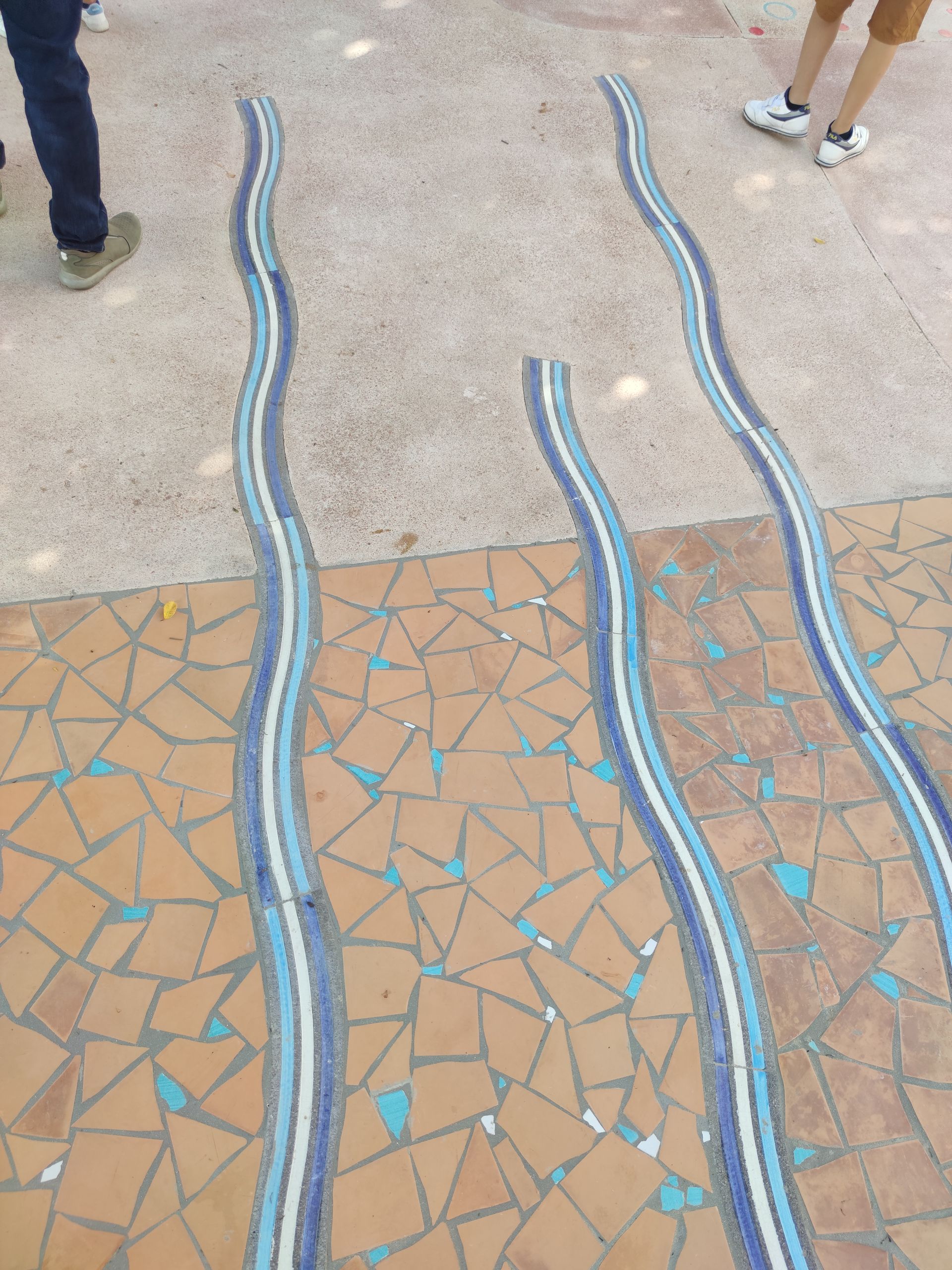 Una persona in piedi su un pavimento piastrellato con linee blu e bianche