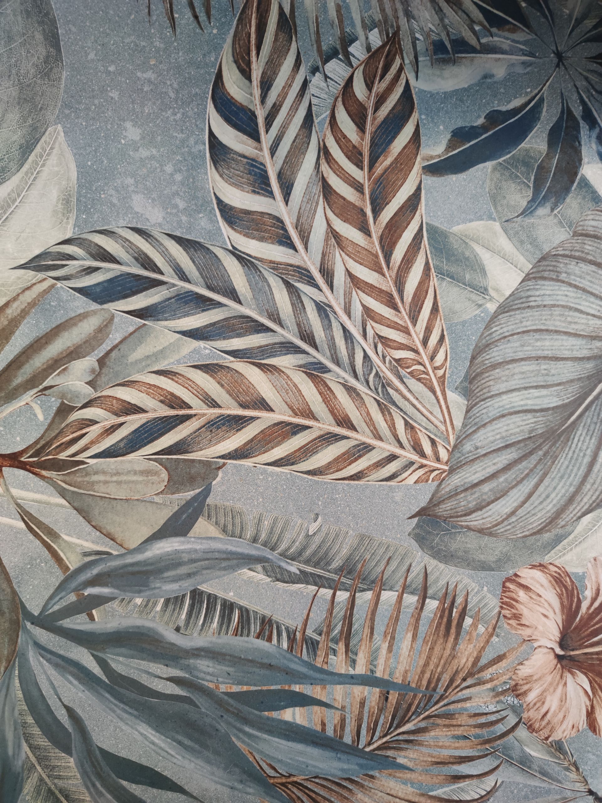 Un primo piano di un dipinto di foglie su una parete.