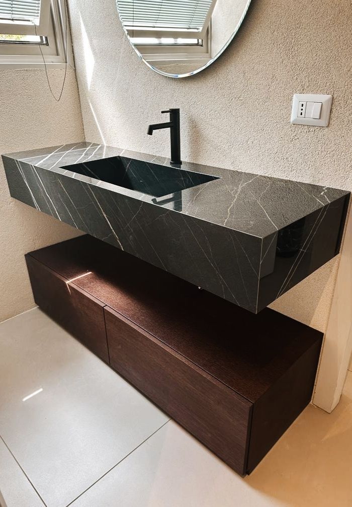 Un bagno con un lavandino e uno specchio sul muro