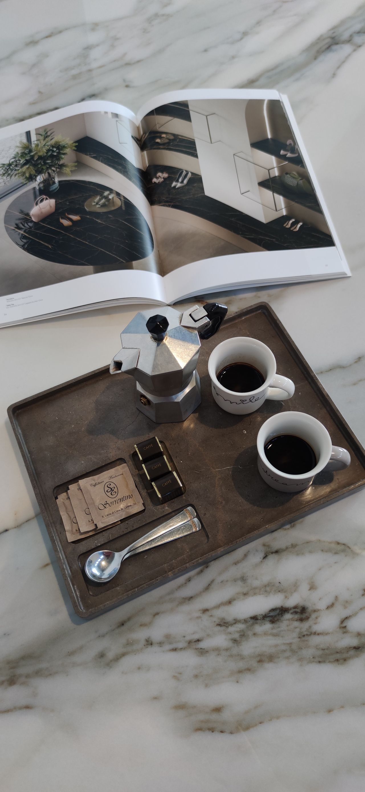 Un vassoio con due tazze di caffè e un libro su un tavolo.