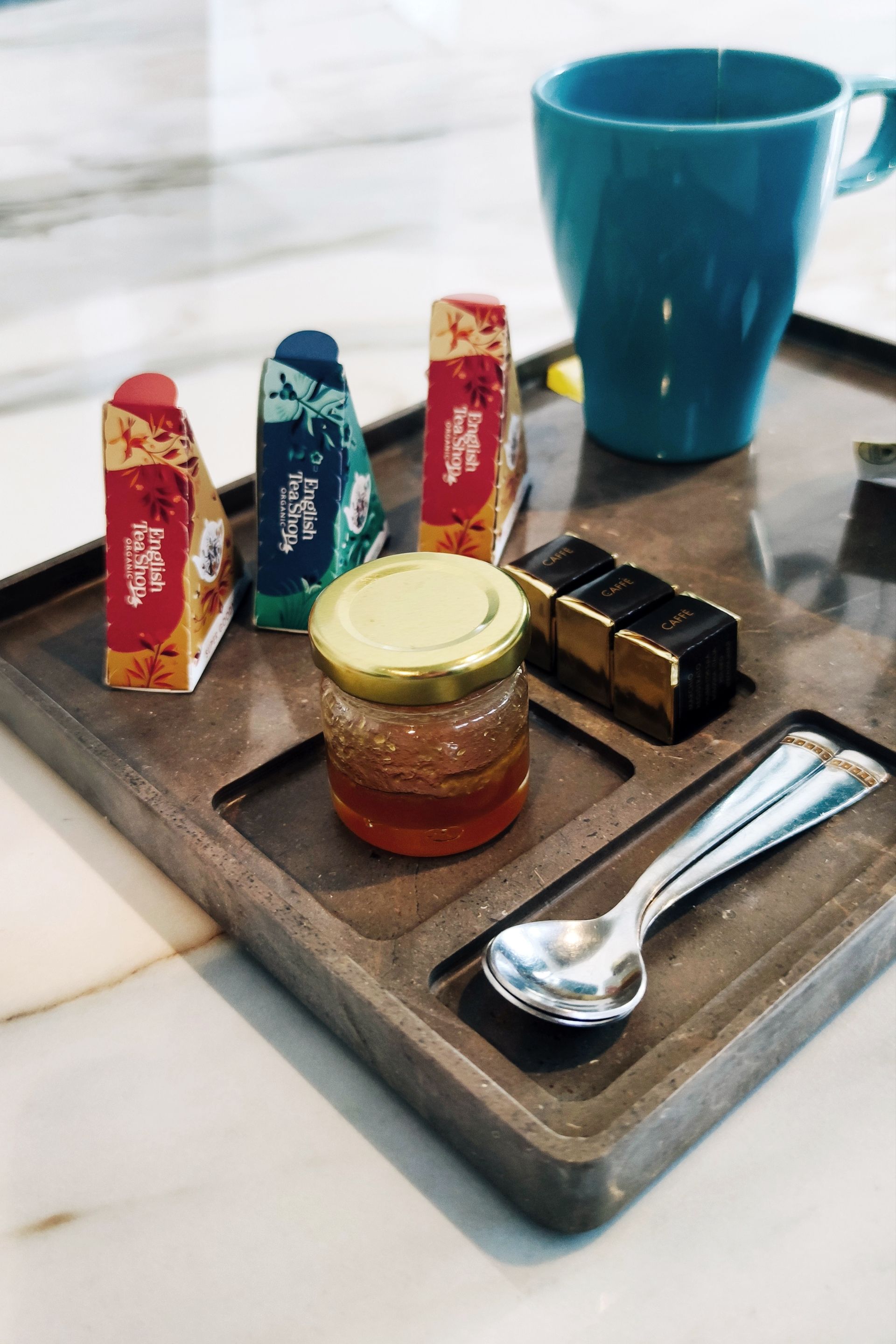 Un vassoio di legno con un barattolo di miele e un cucchiaio sopra