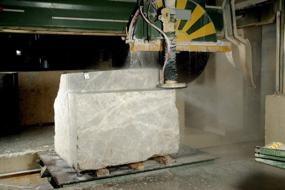 Un grande blocco di pietra viene tagliato da una macchina.