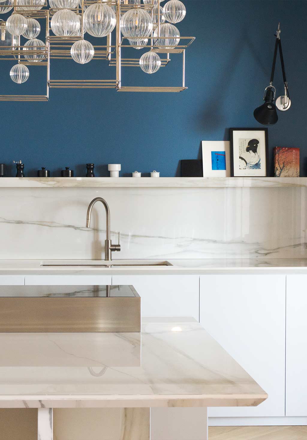 Una cucina con mobili bianchi e una parete blu