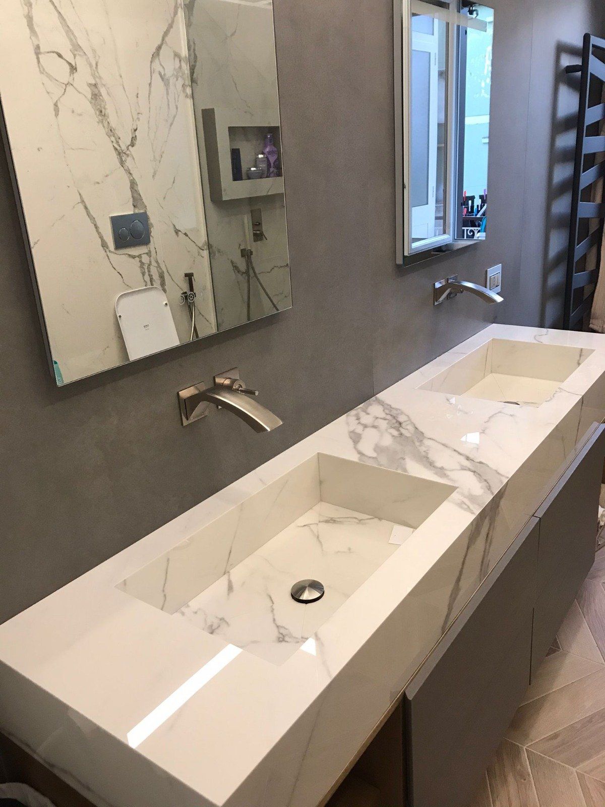 Un bagno con due lavandini e uno specchio sul muro