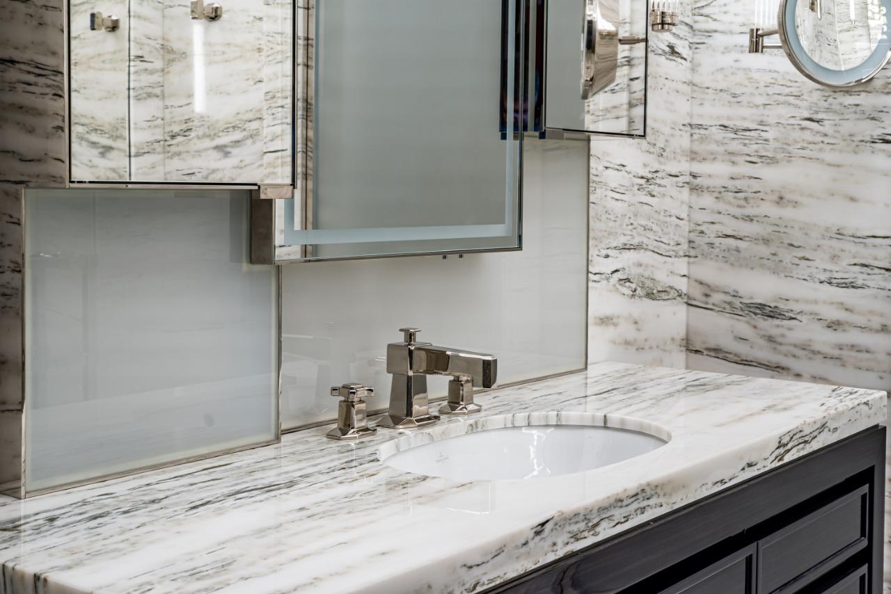 Un bagno con lavandino, specchio e armadietto dei medicinali.