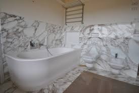 C'è una vasca da bagno nel bagno con pareti in marmo.