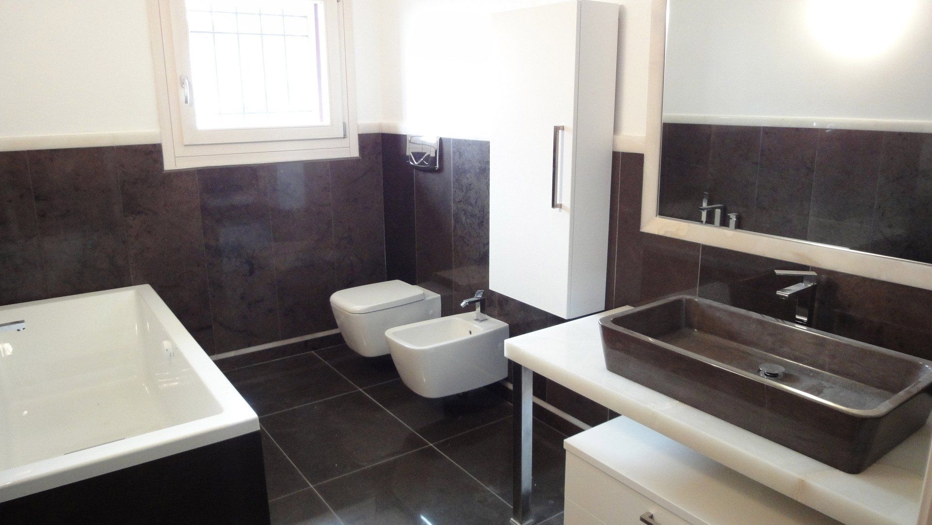 Un bagno con due wc e un lavandino