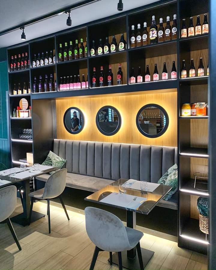 Un ristorante con tavoli e sedie e bottiglie sugli scaffali