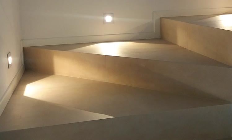 Una rampa di scale con una luce in fondo.