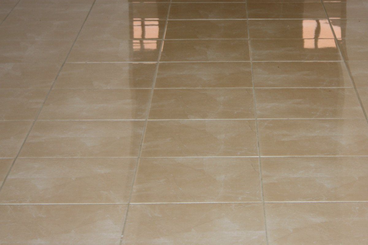 Un primo piano di un pavimento piastrellato con una finestra riflessa.