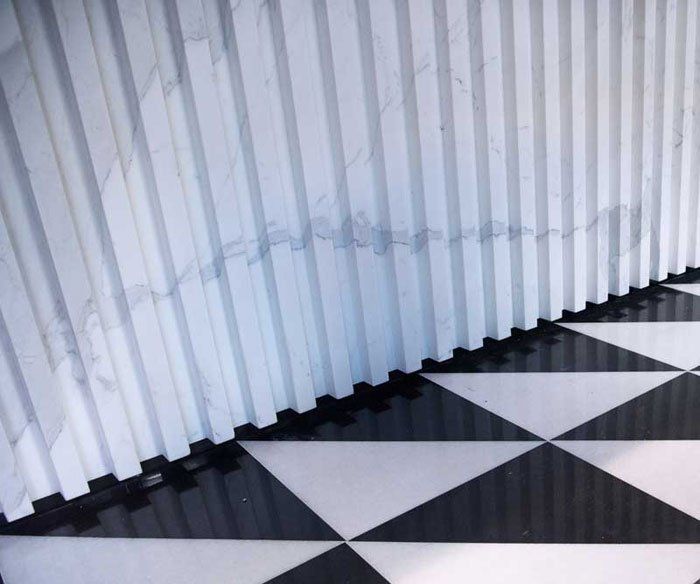 Un pavimento a scacchi bianchi e neri con una parete bianca