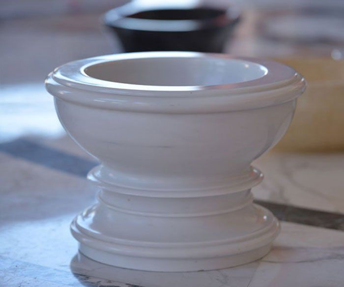 Una ciotola bianca è appoggiata su un tavolo di marmo.