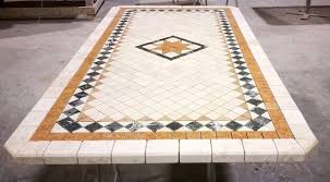 Un tavolo decorato con un mosaico è appoggiato su un pavimento di cemento.