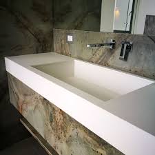 Un lavandino del bagno con un piano in marmo e uno specchio.