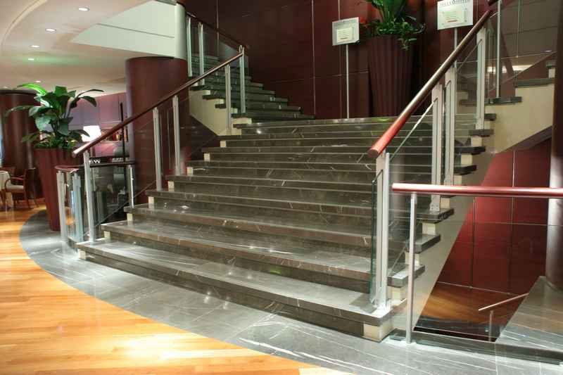Una serie di scale con una ringhiera in vetro in un edificio
