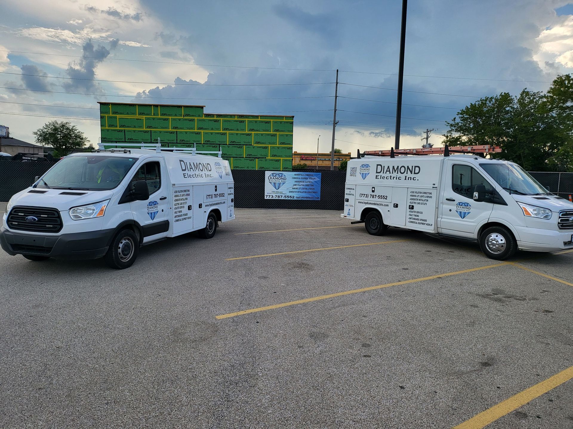 Two white vans are parked next to each other in a parking lot.
