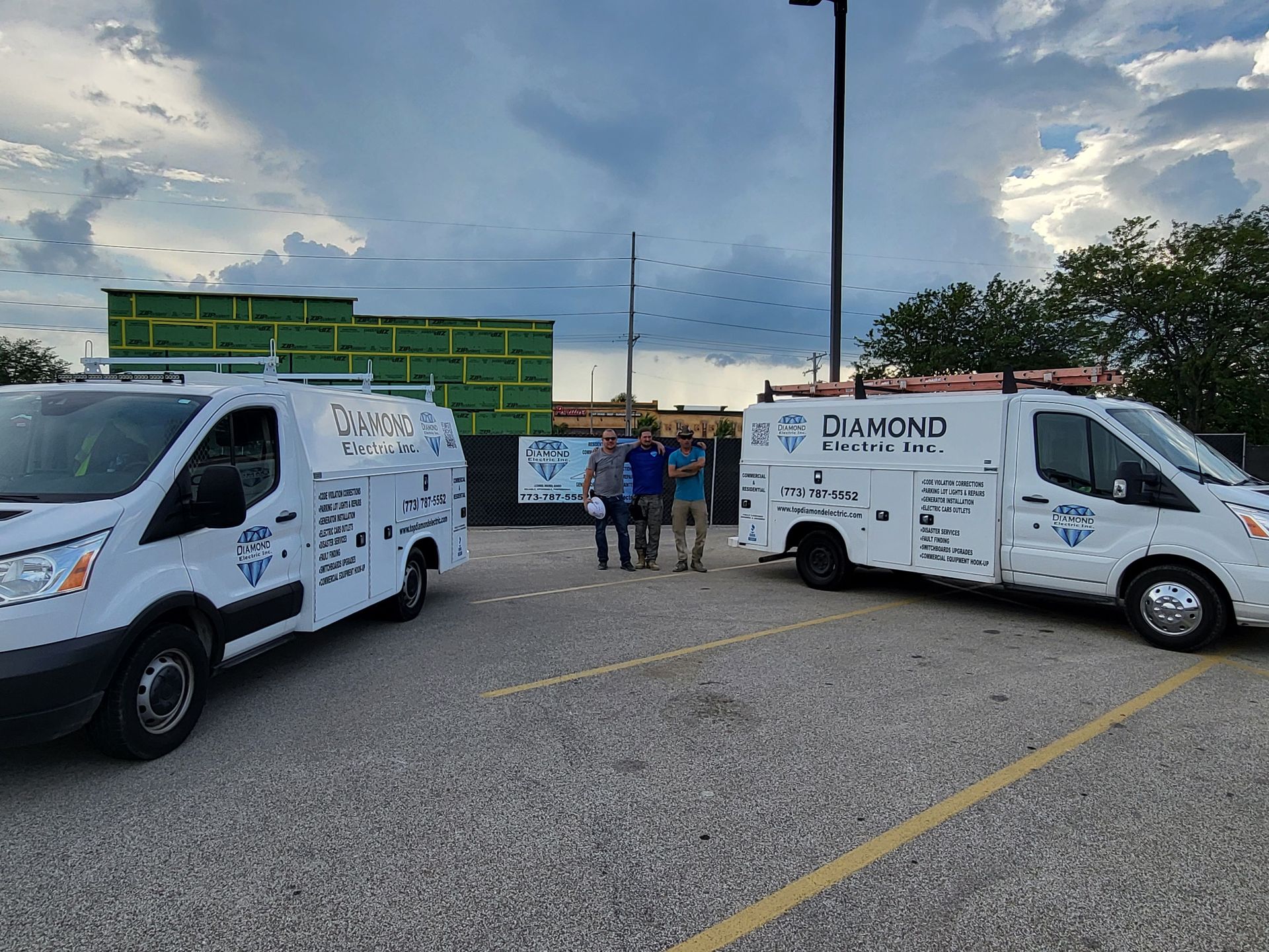 Two white vans are parked next to each other in a parking lot.