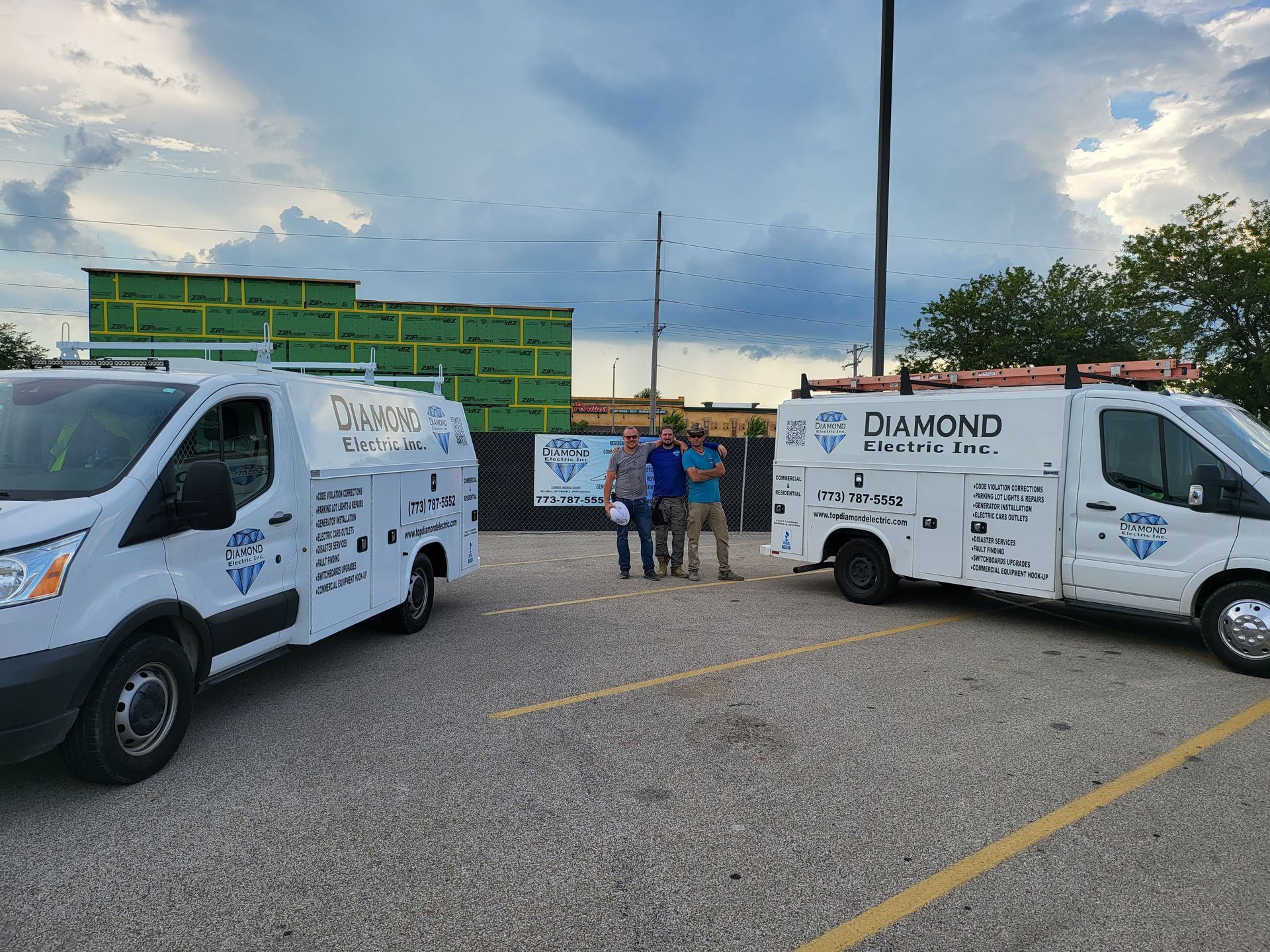 Two white vans are parked next to each other in a parking lot.