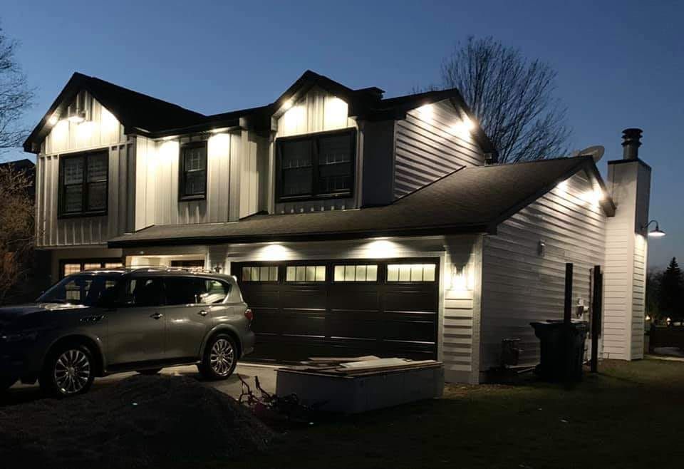 A car is parked in front of a house at night.