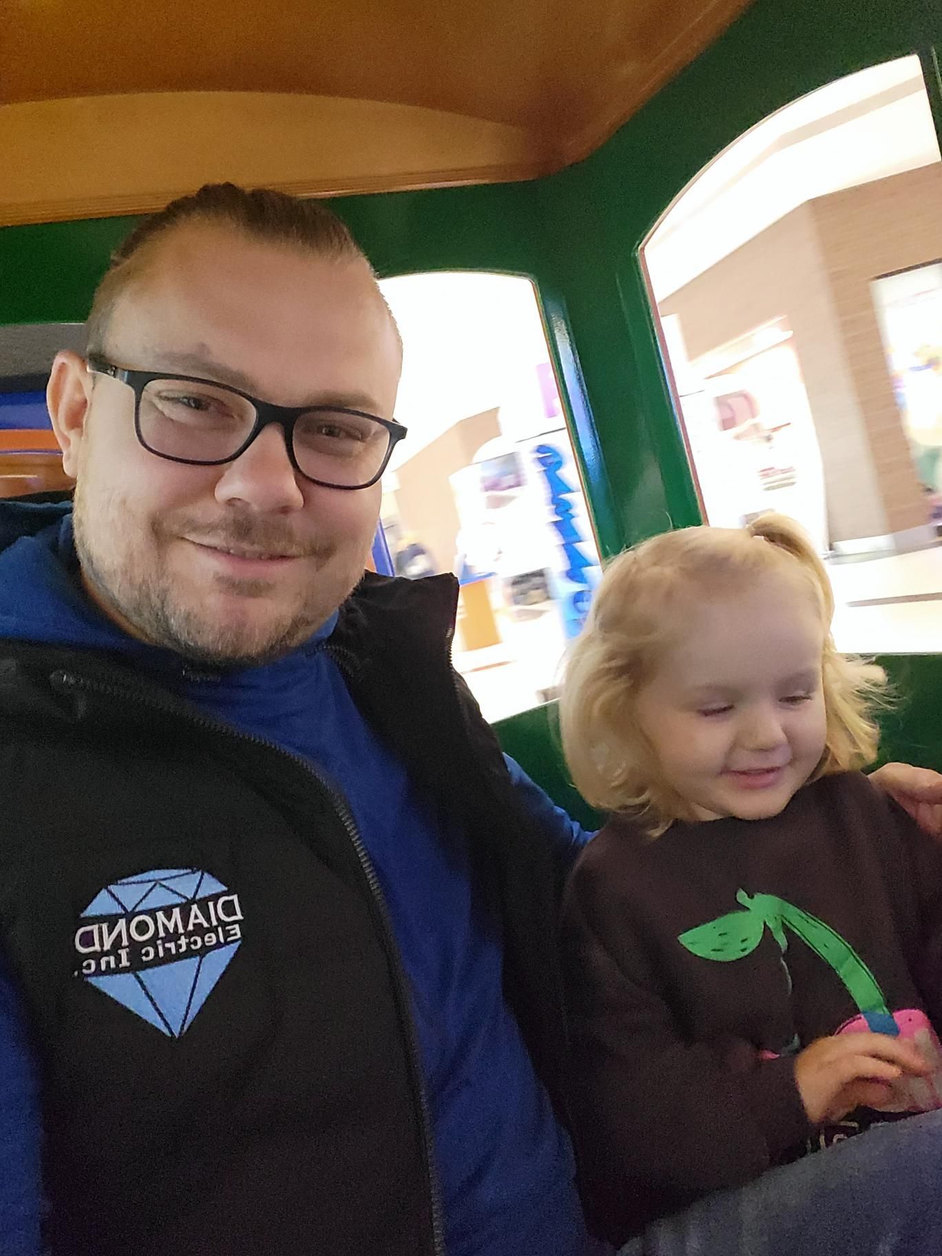 A man and a little girl are sitting on a train.