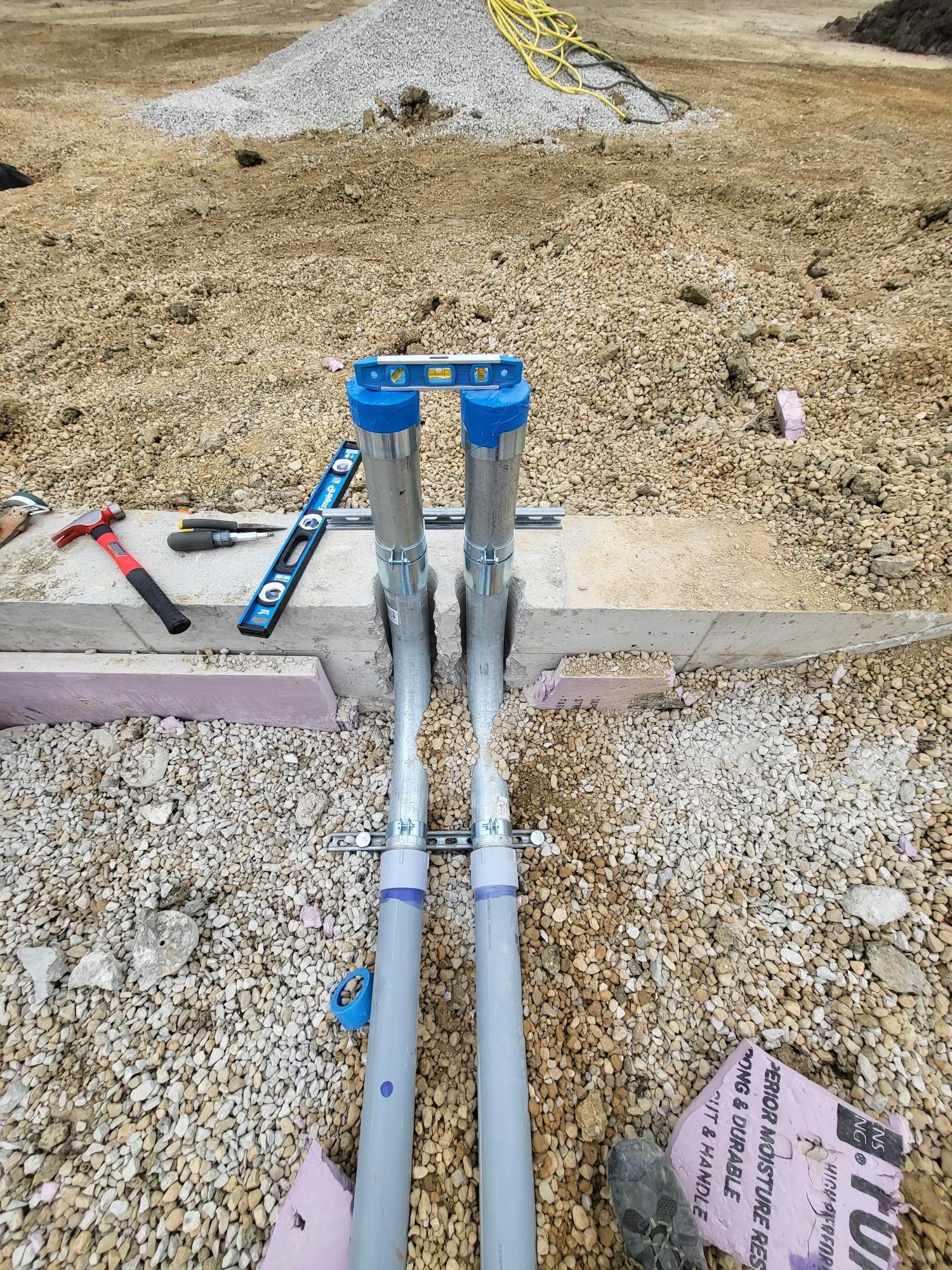 A couple of pipes sitting on top of a pile of gravel.