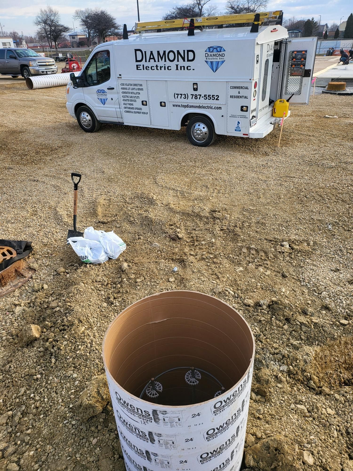 A white van is parked in a dirt field next to a cardboard box.
