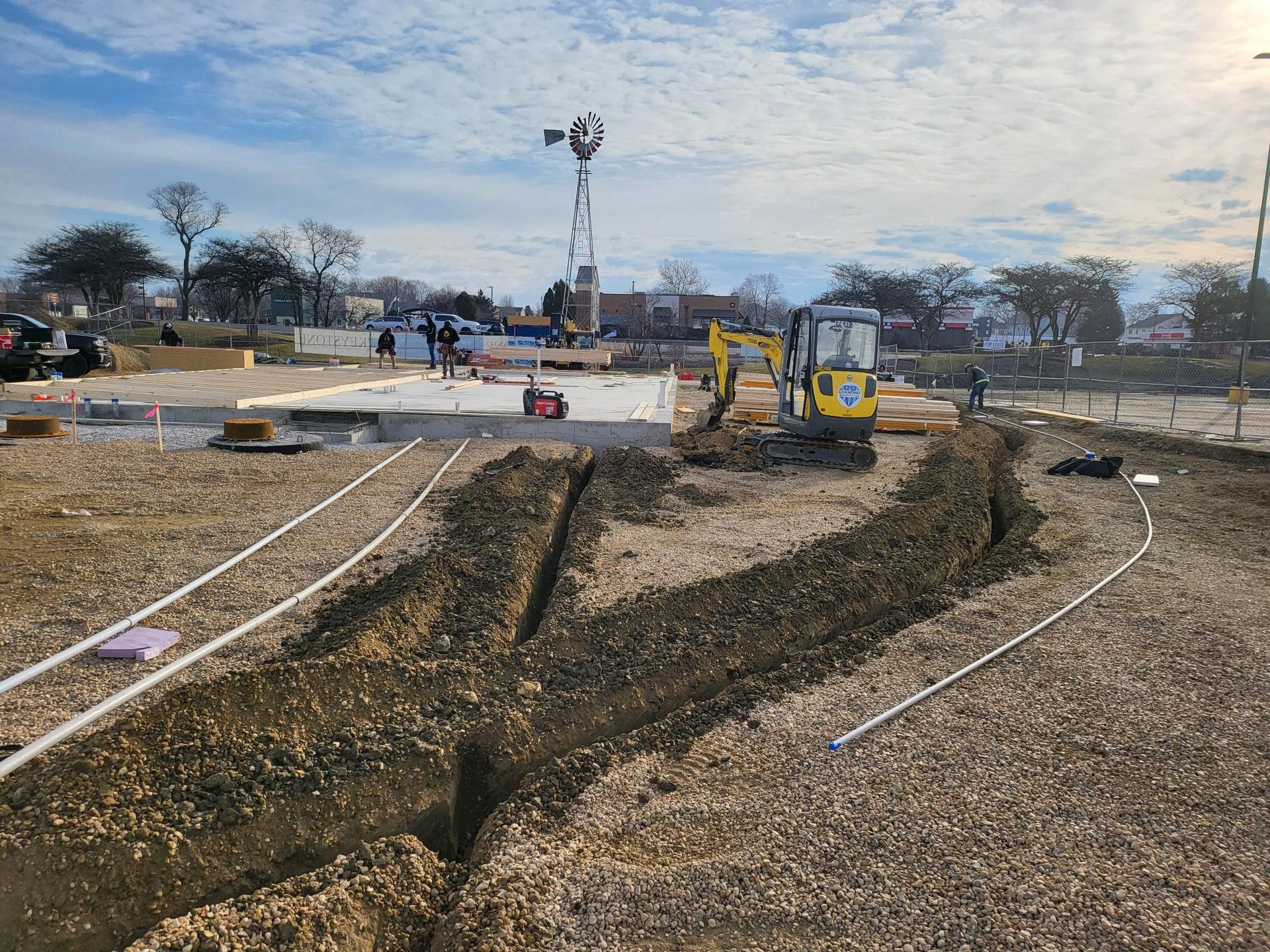 A yellow excavator is digging a hole in the dirt in a construction site.