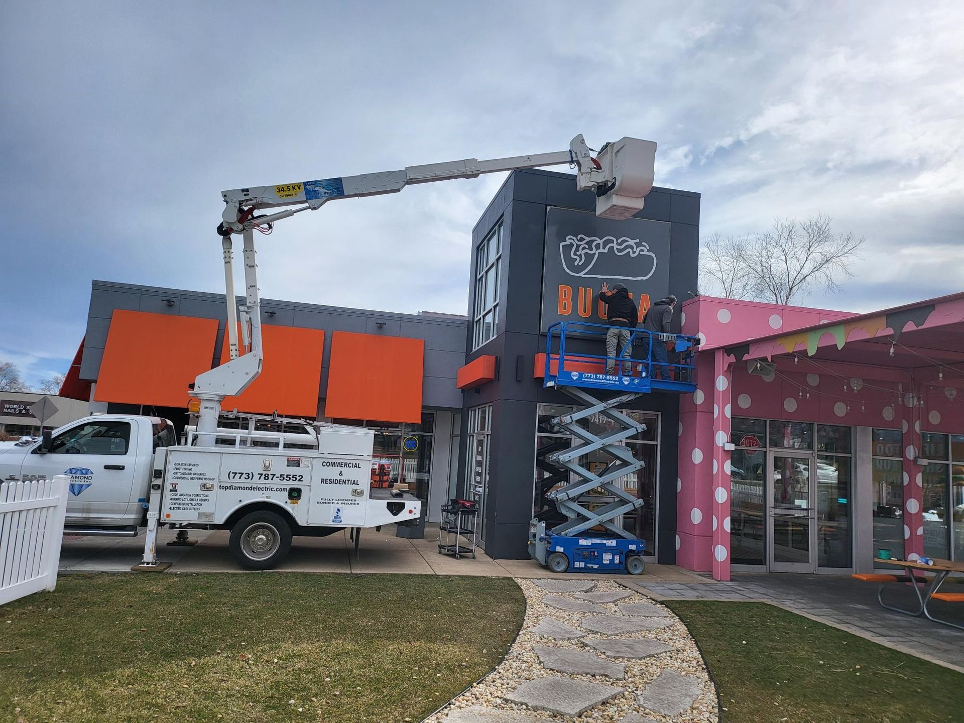 A crane is being used to install a sign on the side of a building.