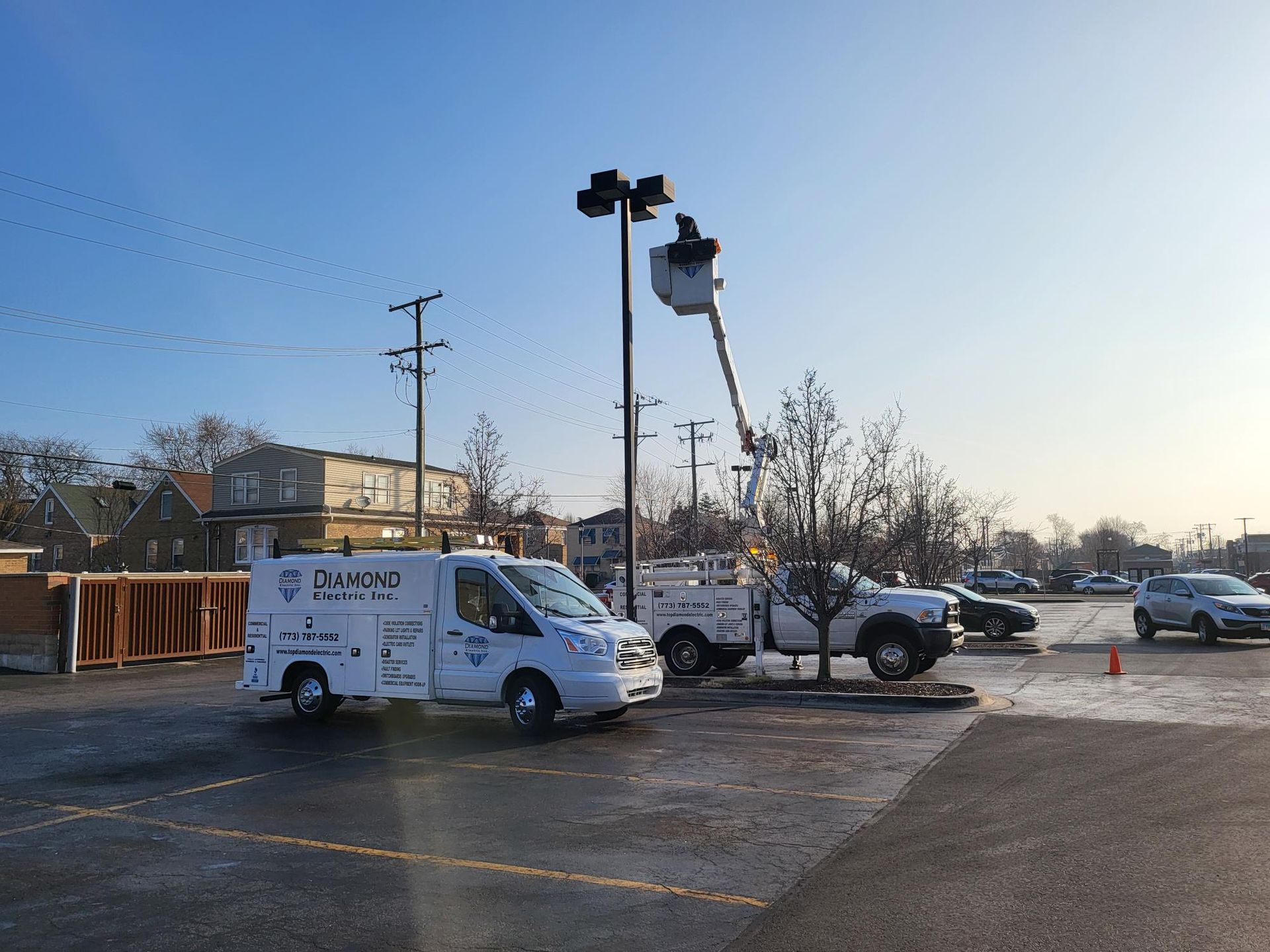 A couple of white vans are parked in a parking lot.