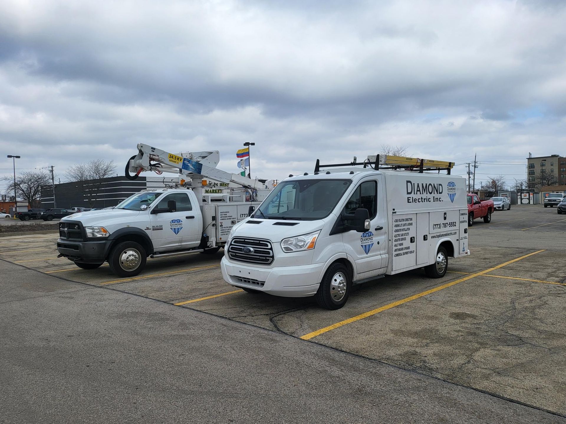 Two white vans are parked next to each other in a parking lot.