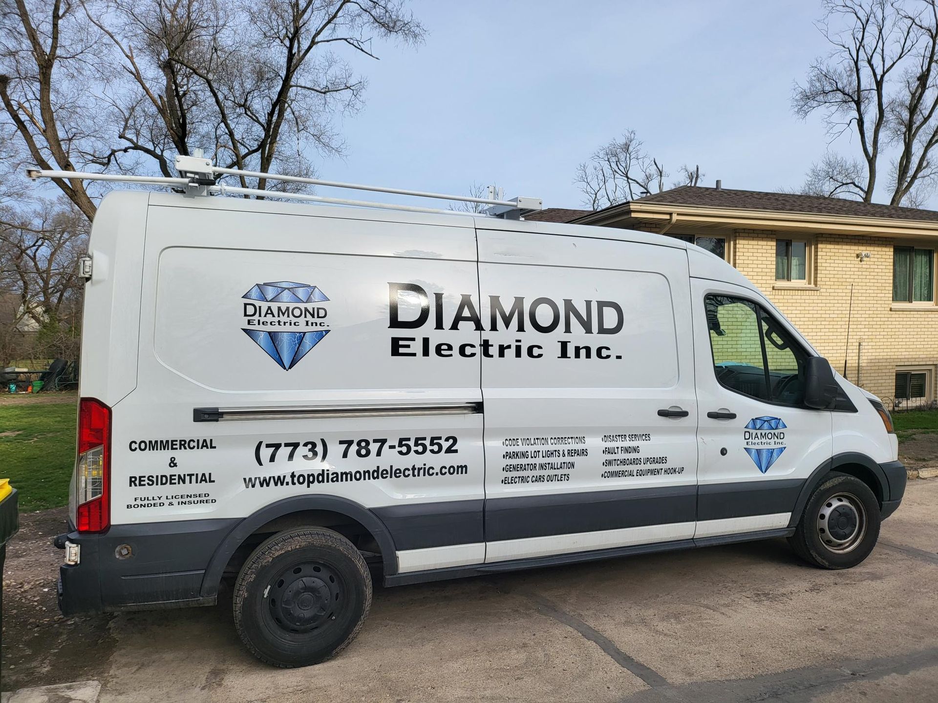 A white van from diamond electric inc. is parked in front of a house.