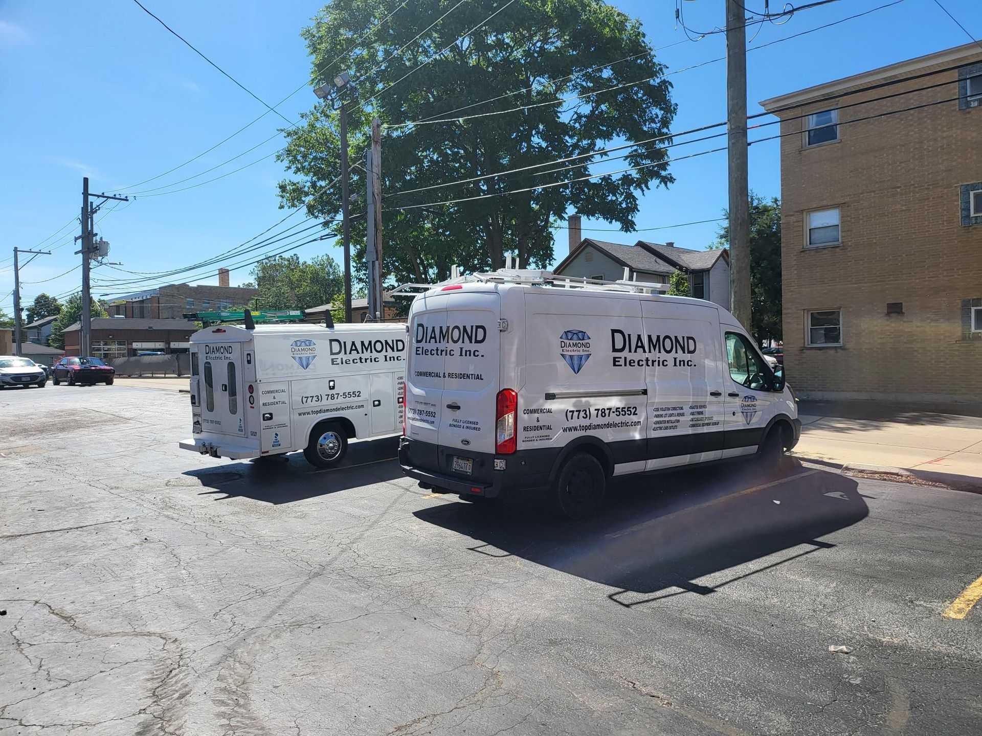Two diamond vans are parked on the side of the road.