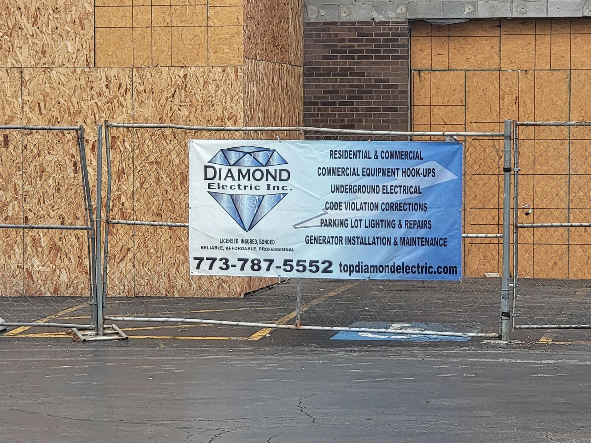 A diamond electric inc. sign is hanging on a fence
