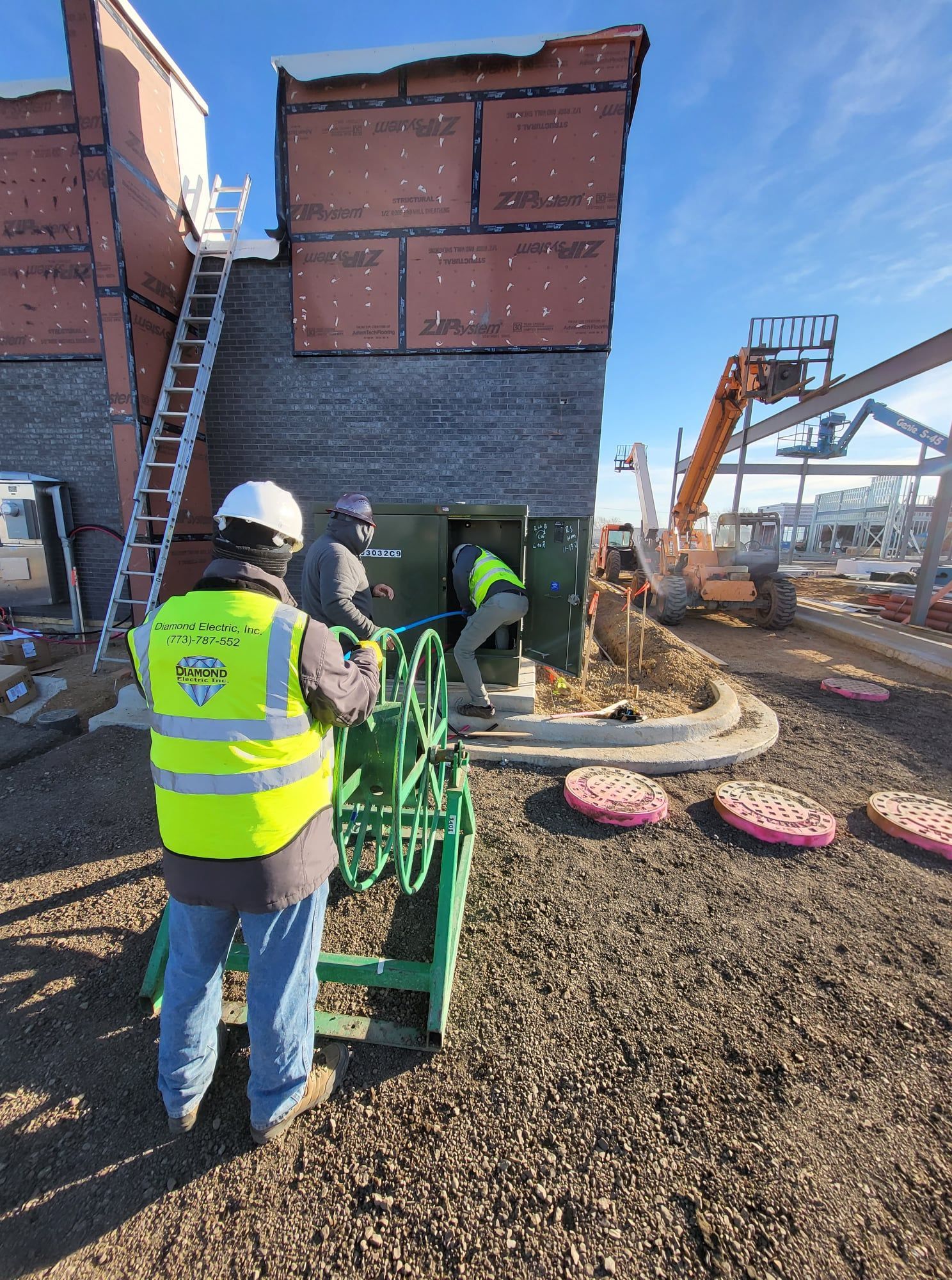 A man in a yellow vest is standing in front of a building.