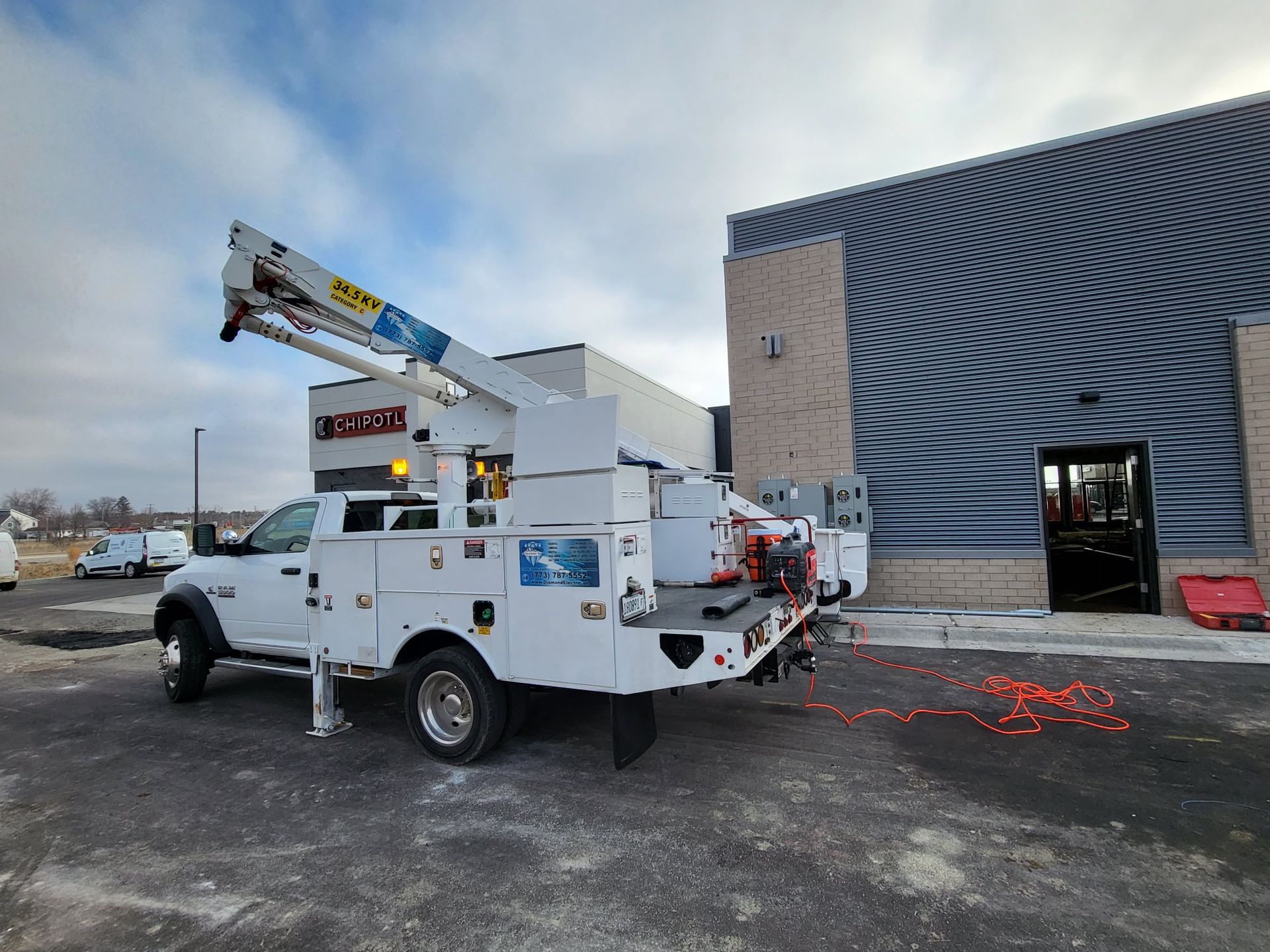 A white utility truck is parked in front of a building.