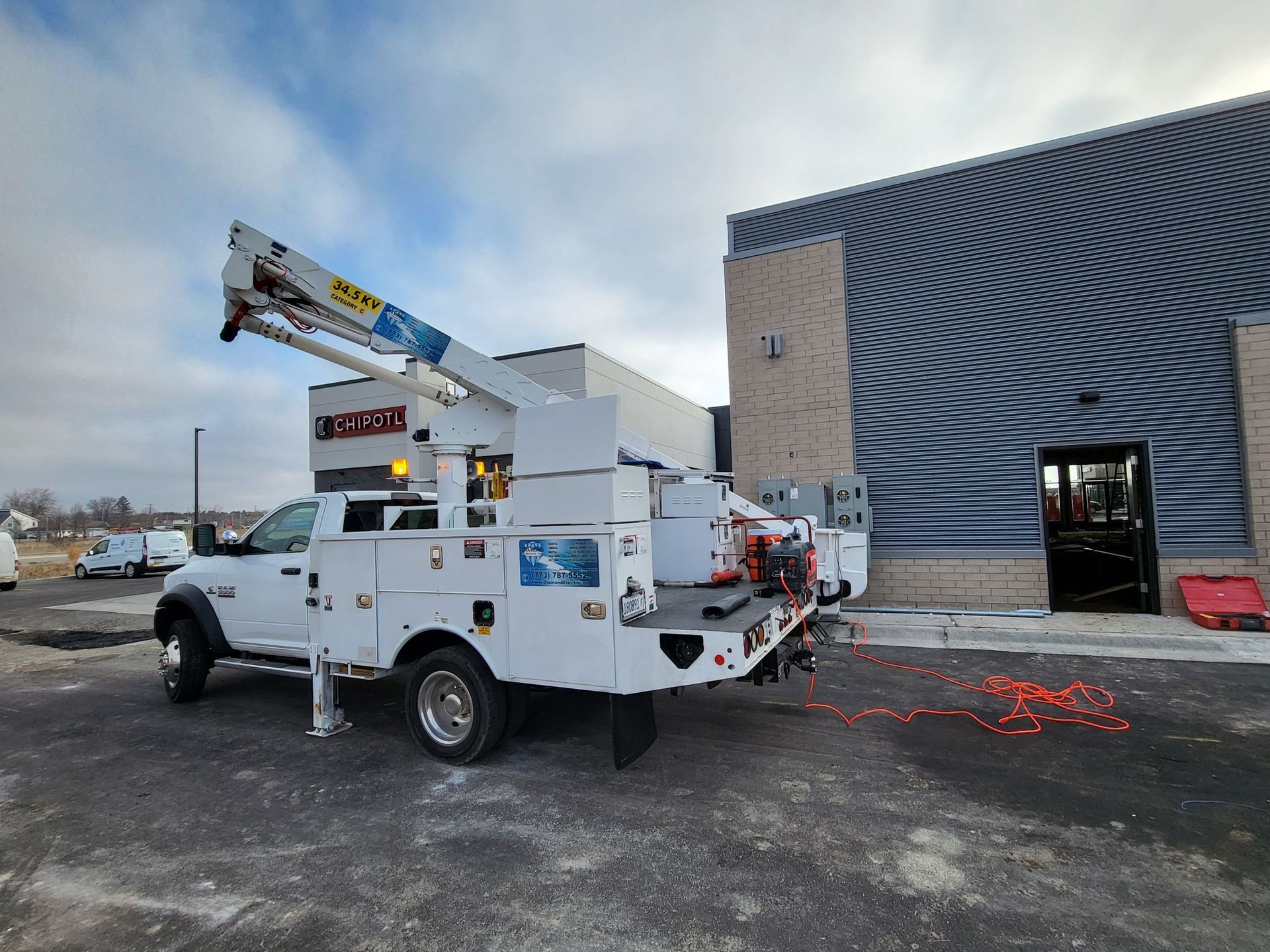 A white utility truck is parked in front of a building.
